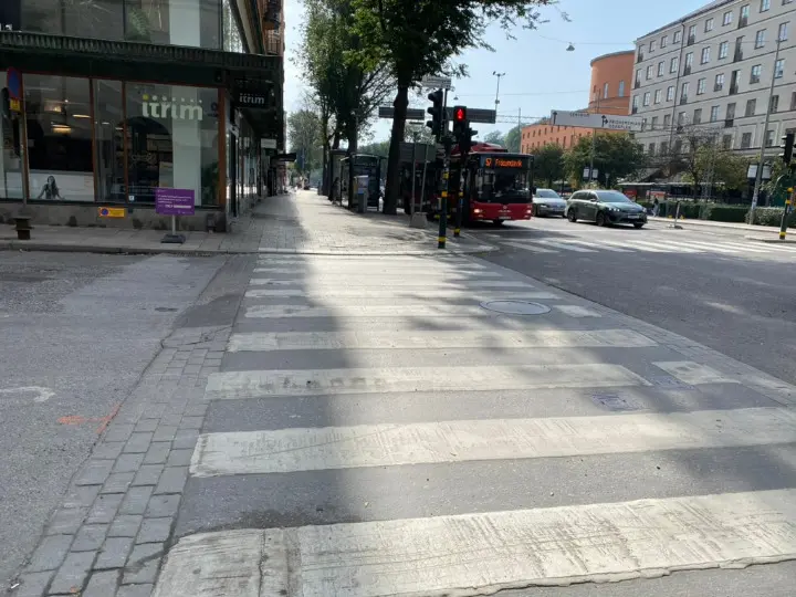 Foto einer Ampel. Der Fussgaengerueberweg ist ein Zebrastreifen.