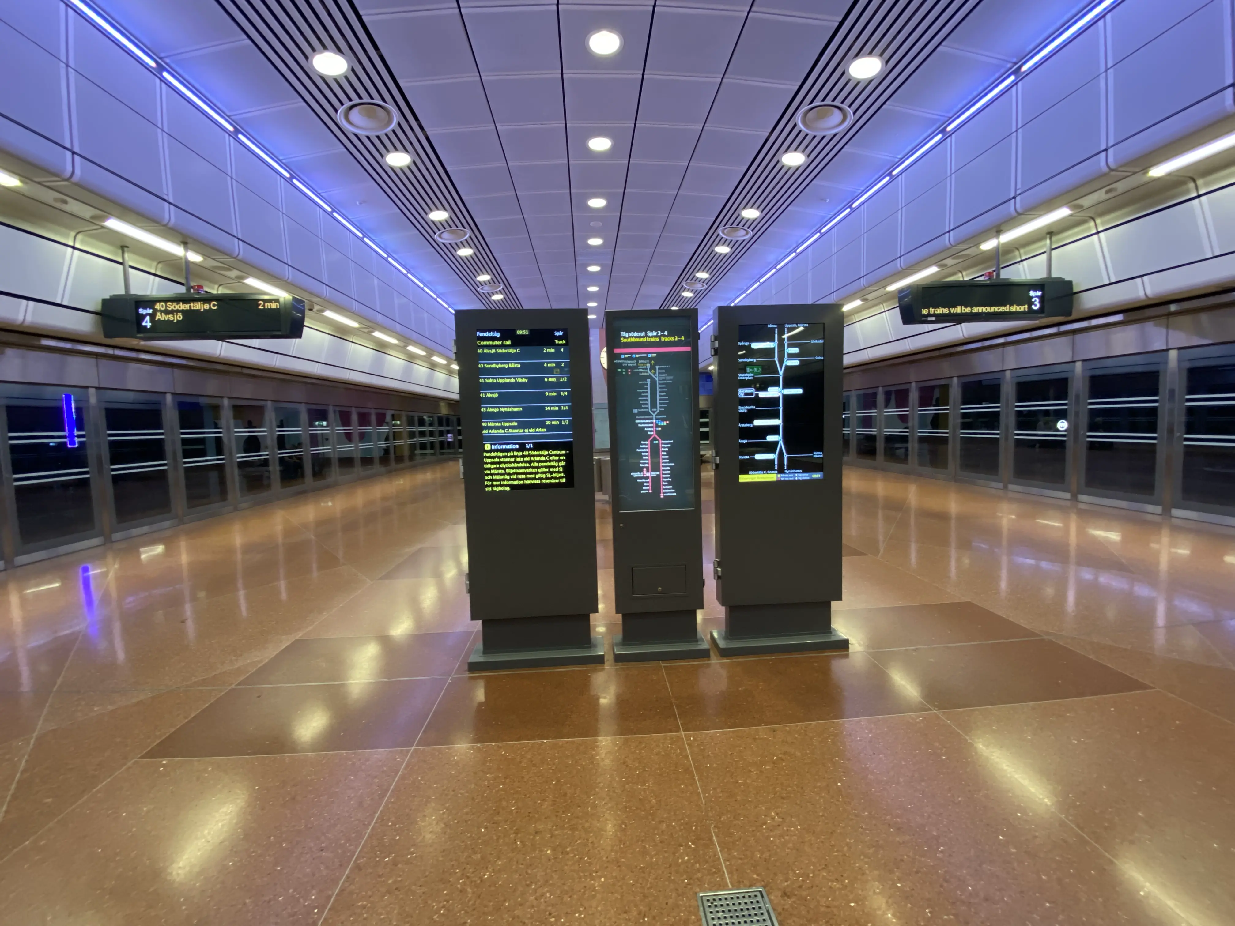 Foto eines Wartebereichs an einem unterirdischen Bahnhof. Der Boden ist sauber.
